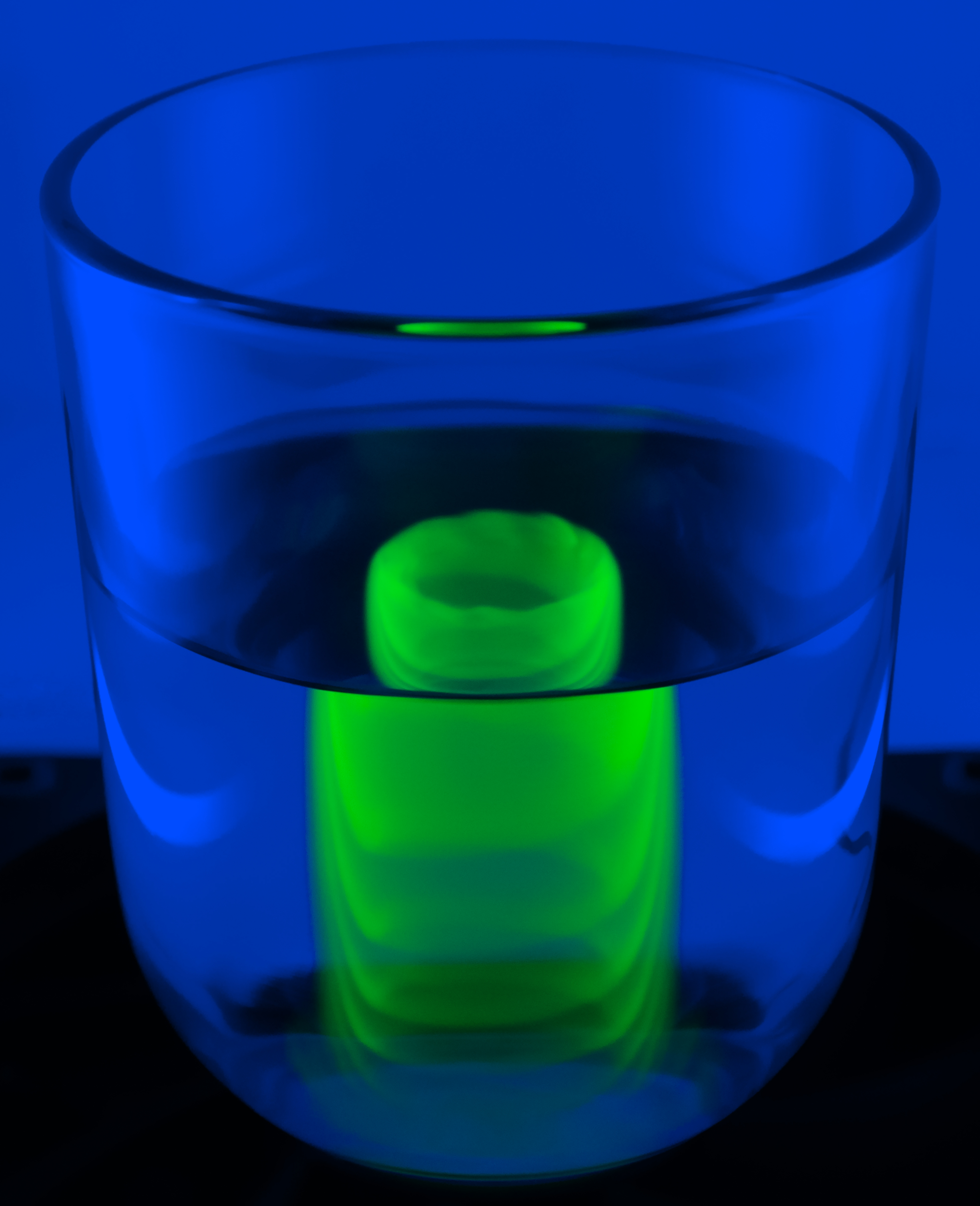 A column is formed in a rotating glass of water as fluorescent green dye is introduced. At low Rossby number, the Coriolis force dominates, controlling the dye motion. This unfiltered UV-illuminated image shows spiral filaments, mirroring the structure of a large-scale natural storm, also governed by the same invisible force.
