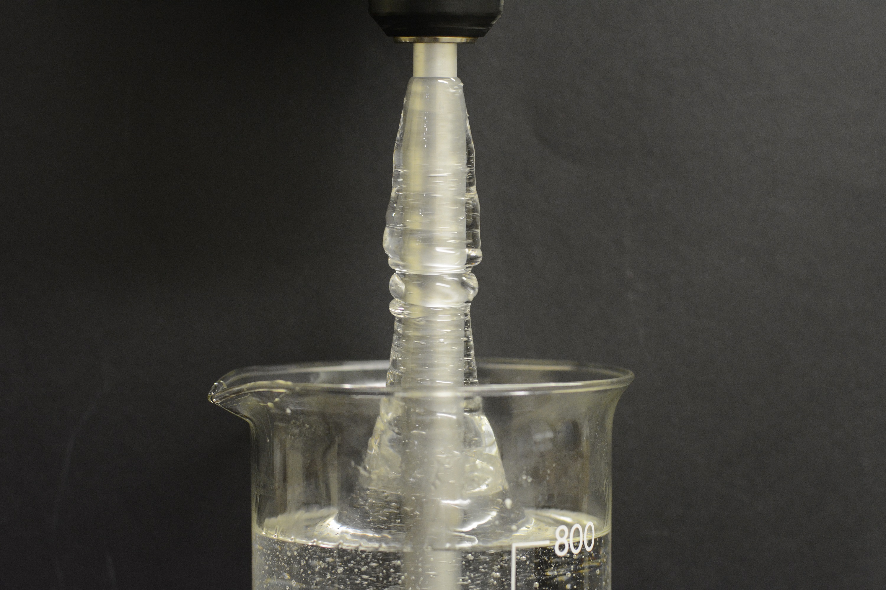 A rotating rod is partially submerged in an aqueous solution (~1wt%) of polyacrylamide acid (PAA).  With inertia present, a Newtonian fluid moves outwards toward the container walls.  Here, however, the fluid climbs the rod due to the elastic stresses generated along the streamlines by the rotation of the rod. The photo is not a composite and has not been enhanced.
