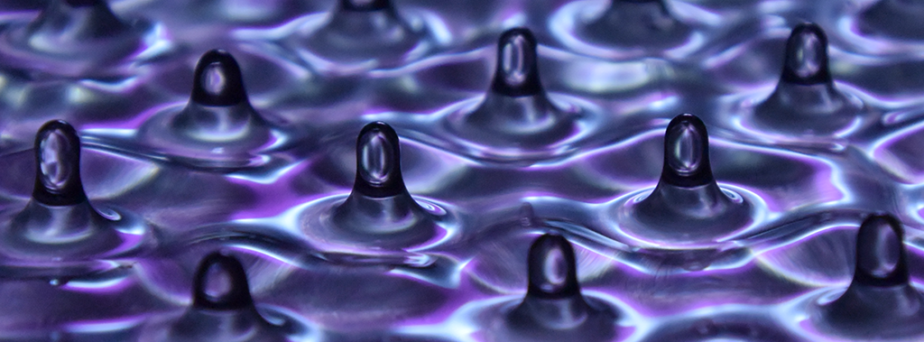 As a liquid bath is perturbed, at a particular acceleration a standing wave, called Faraday waves, will appear on the whole surface of the bath. Regular square patterns are observed for single-frequency forcing and the wavelength depends on the liquid properties and exciting frequency. The regular pattern becomes more complex by adding a second frequency component into the forcing signal. A slight presence of the second frequency does not affect the instability as triggered by the first. However when both acceleration are large, the more complex quasi patterns are produced. (Liquid bath: Silicone oil 20 Cst, light with pink and white diffuse, Nikon camera with macro lens.)