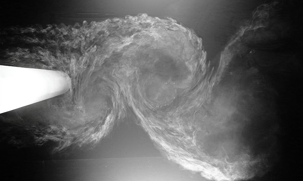 Flow visualization for a circular cylinder section in laminar flow conditions within a wind tunnel. Non-composite photograph, standard touch-up with (contrast, highlights, shadows etc.)

